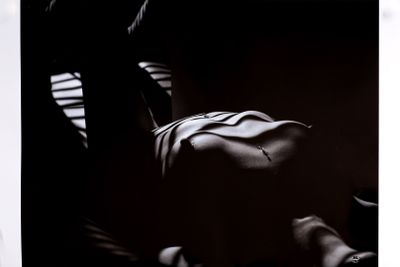 photographie en noir et blanc d'une femme allongée sur un lit, de dos à l'appareil photo