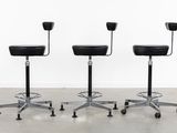 three black stools sitting on top of each other in a room