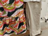 a woman standing next to a pile of clothes