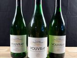 three bottles of wine sitting on top of a wooden table