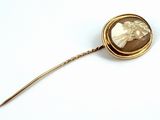 a gold brooch with a picture of a woman on it