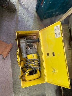 une boîte jaune posée par terre, contenant des outils