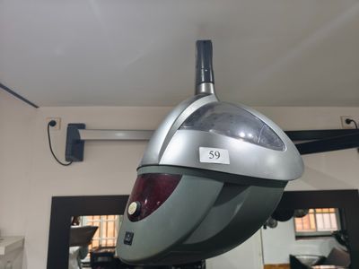 un objet argenté et noir suspendu au plafond dans une pièce