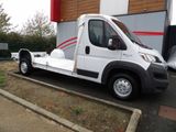 un petit camion blanc garé devant un immeuble