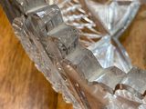 a glass bowl on a wooden table with a spoon in it