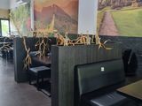 tables and benches in a restaurant with a large painting on the wall