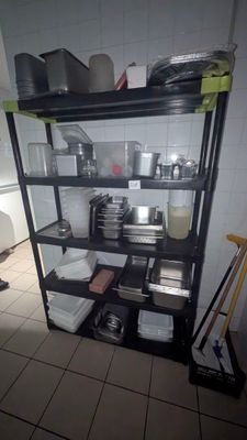 une étagère avec des casseroles et des poêles dans une cuisine