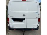 the back end of a white van parked on the side of a road