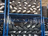 tires stacked on a rack in a warehouse with a lot of them