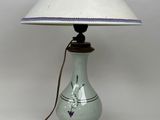 une lampe posée sur une table, avec un abat-jour blanc