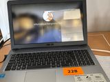 un ordinateur portable posé sur un bureau, avec une étiquette de prix dessus