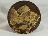 gold plate with a fish on it on a white background