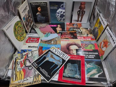 une valise remplie de livres et de magazines posée par terre