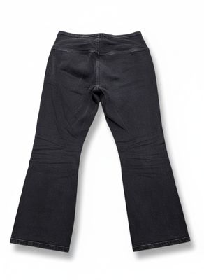 Ce jean est noir et comporte une fermeture éclair sur le côté.
