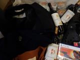 a pile of wine bottles and other items on a bed