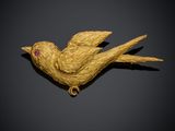une image représentant une broche en forme d'oiseau doré sur fond noir