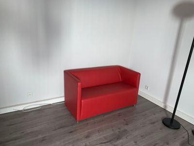 un canapé rouge dans un coin de la pièce