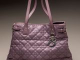 purple quilted tote bag with a lock on the handle