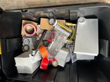 a black container filled with assorted items on the ground