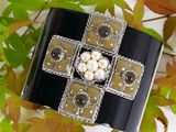 an image of a bracelet with pearls and a cross on it