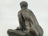 statue of a man sitting on his knees on a white background