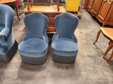 deux chaises bleues et une table dans une pièce où il y a beaucoup de meubles