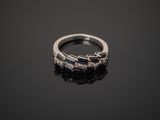 a close up of a diamond and sapphire ring on a black surface