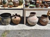 many pots and vases on display on the sidewalk