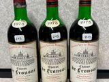 trois bouteilles de vin rouge sont alignées sur un comptoir