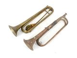 deux vieux trombones en laiton posés l'un à côté de l'autre sur une surface blanche