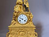 a gold clock with a statue on top of it