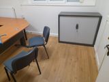two chairs and a cabinet in the corner of a room