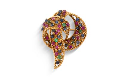 un gros plan sur une broche en or sertie de pierres multicolores