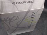 a box of wine sitting on the floor next to a bottle of wine