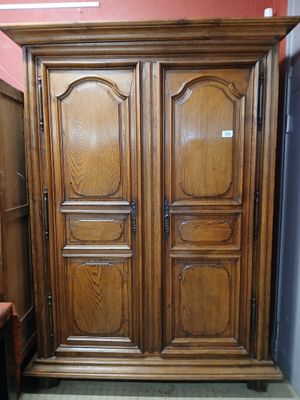 a large wooden armoire in the corner of a room