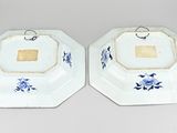 two blue and white plates with flowers on them on a table
