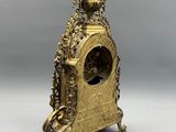 an image of a gold clock sitting on top of a table