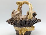 figurine of a cat in a basket on a white background