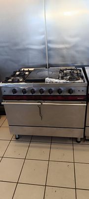 une cuisinière et un four dans une cuisine au sol carrelé