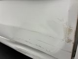 a white car that has a rusted door handle on it
