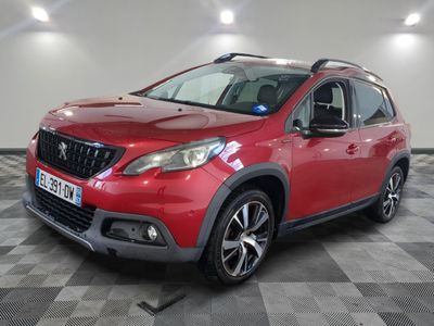 une voiture rouge garée dans un garage au sol en damier