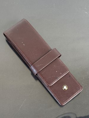 a brown leather wallet with a gold button on it