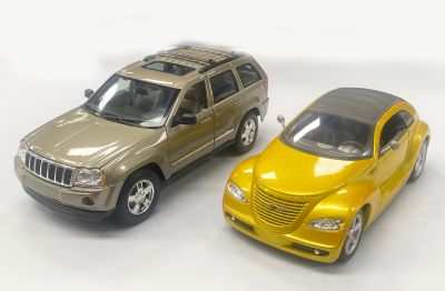 two toy cars sitting next to each other on a white surface