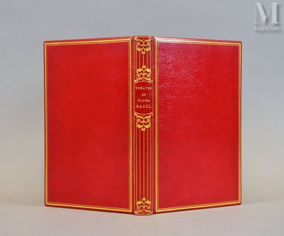 un vieux livre rouge posé sur une table à côté d'un mur blanc