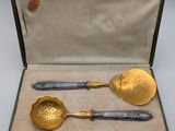 two spoons and a ladle in a case