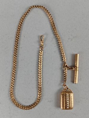 an image of a gold necklace with a bell charm and a chain
