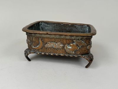 an old metal planter with a bird design on it