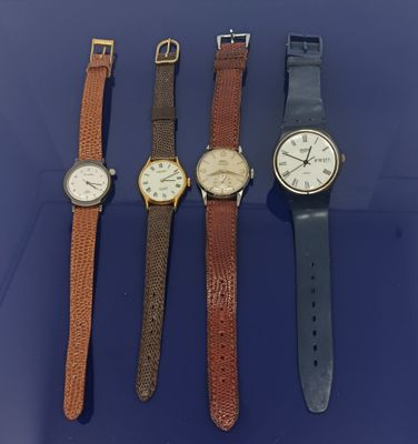 Quatre modèles de montres différents sont alignés sur un fond bleu
