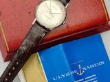 a watch sitting on top of a book next to a book
