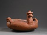 an old clay vessel with a bird on top of it